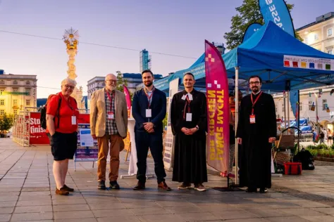 Eine Helferin der Langen Nacht der Kirchen mit Vertetern verschiedener Kirchen vor dem Segenszelt bei der ökumenischen Aktion Segen to go – organisiert vom Forum der christlichen Kirchen in OÖ. Vlnr: Helferin (Name unbekannt), Rev. Tony Addy (United Reformed Church), Kristoffer Jonasson (Römisch-katholische Kirche, Ökumene-Referent), Pfarrer Gernot Mischitz (Evangelische Kirche A. B.), Priester Goran Ostojic (Serbisch-orthodoxe Kirche).