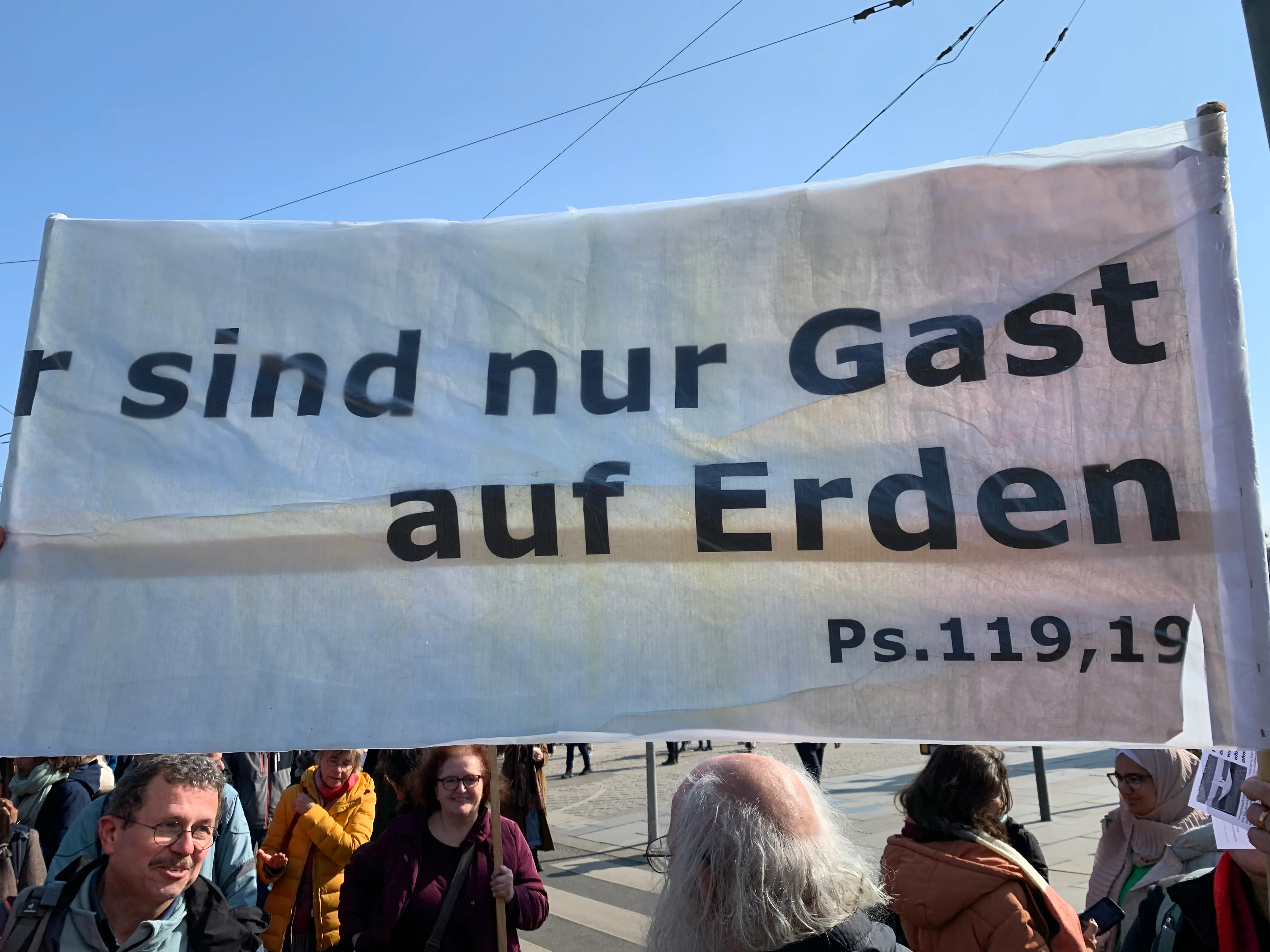 Religions for Future beim Klimastreik am 3. März in Wien Transparent, erstellt von Andrea Kampelmüller (unterhalb des Plakates mit dunkelroter Jacke, links daneben Pfarrerin i.R. Ulrike Frank-Schlamberger)